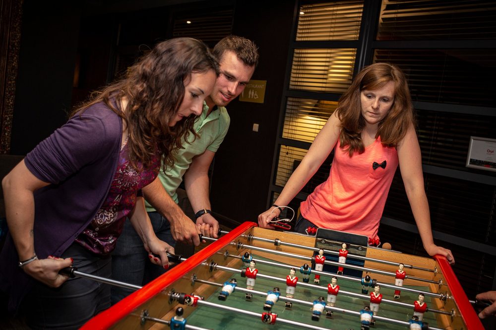 Collègues jouant au baby-foot lors d'une animation de jeux café