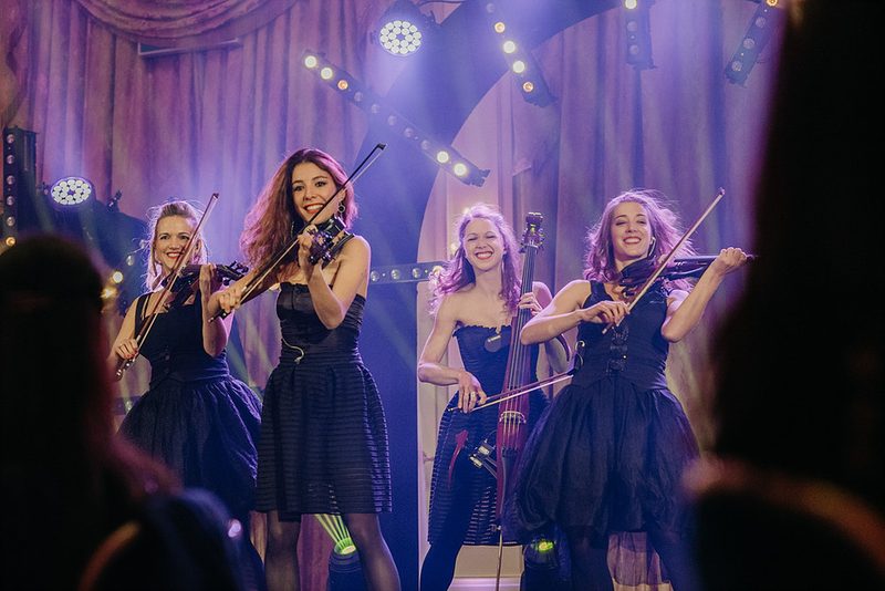 Quatuor de musiciennes à cordes sur scène, violons et violoncelle électrique